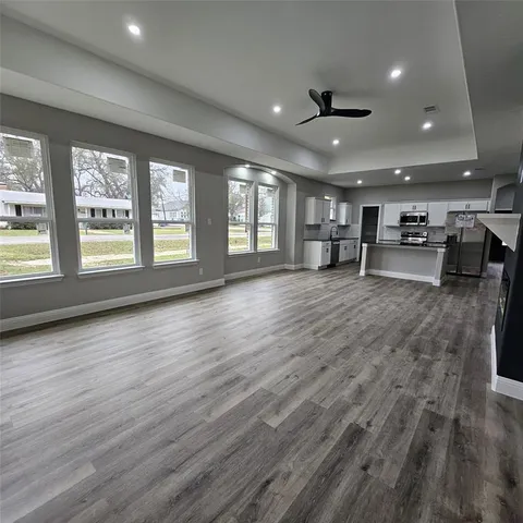 a view of a room with lots of wooden furniture and windows