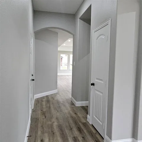 a view of a hallway with wooden floor and a hallway