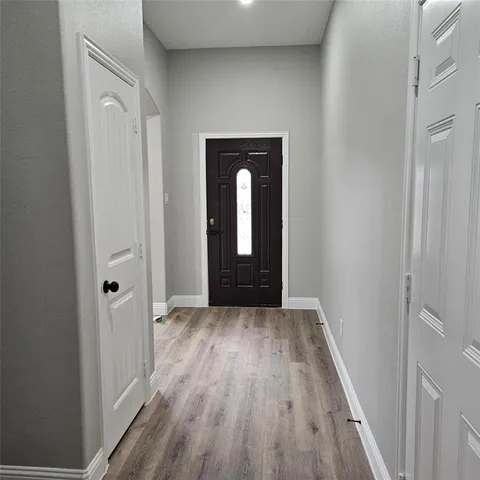 a view of a hallway with wooden floor