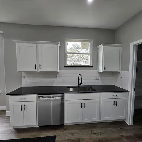 a kitchen with stainless steel appliances granite countertop a sink and a stove