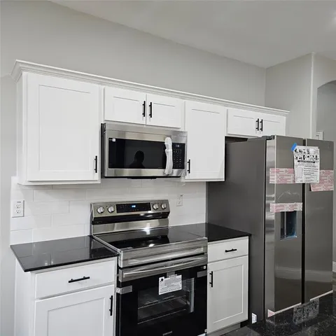 a kitchen with stainless steel appliances a stove a microwave and a refrigerator