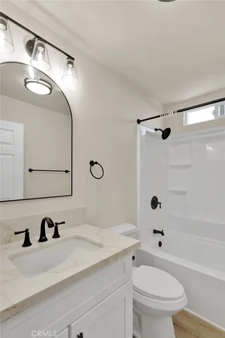 a bathroom with a sink vanity granite toilet tub and shower
