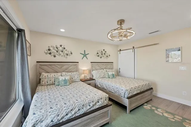 a bedroom with two separate beds and painting on the wall