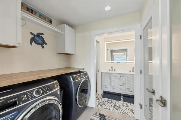 a view of bathroom with washing machine and mirror