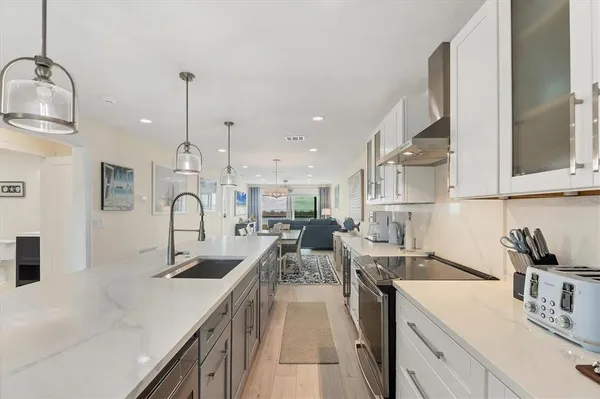 a kitchen with sink a stove and cabinets