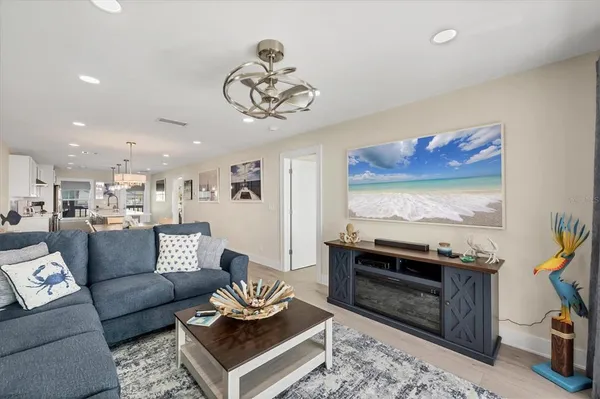 a living room with furniture a flat screen tv and kitchen view