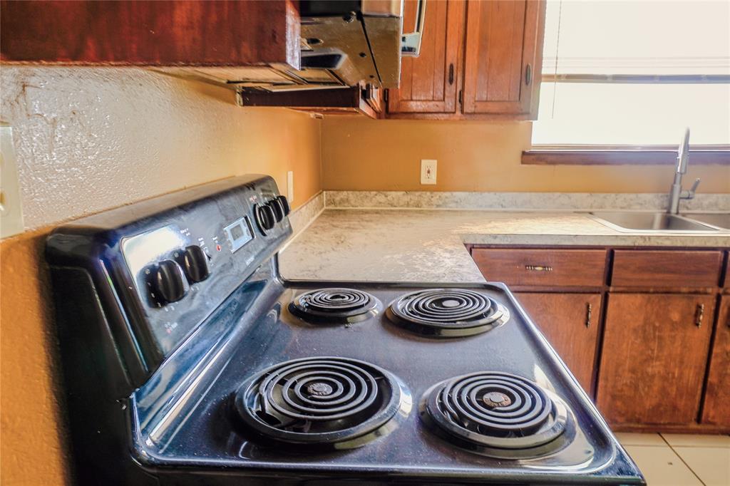 300 Coury Road Everman, TX 76140 - Photo 9 of 29 a kitchen with a stove and a microwave