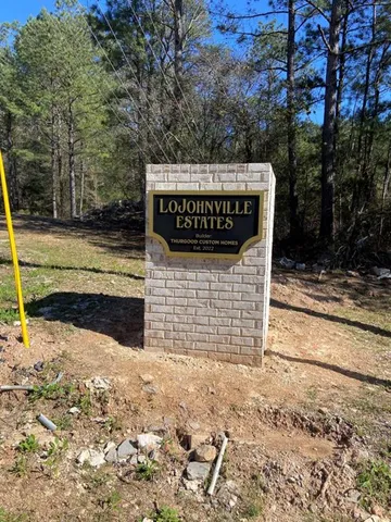 a view of a wooden house with large trees