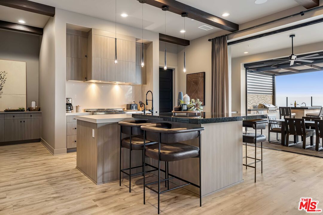 20524 Shelley Lane Porter Ranch, CA 91326 - Photo 20 of 73 a kitchen with stainless steel appliances kitchen island granite countertop a table chairs sink and cabinets