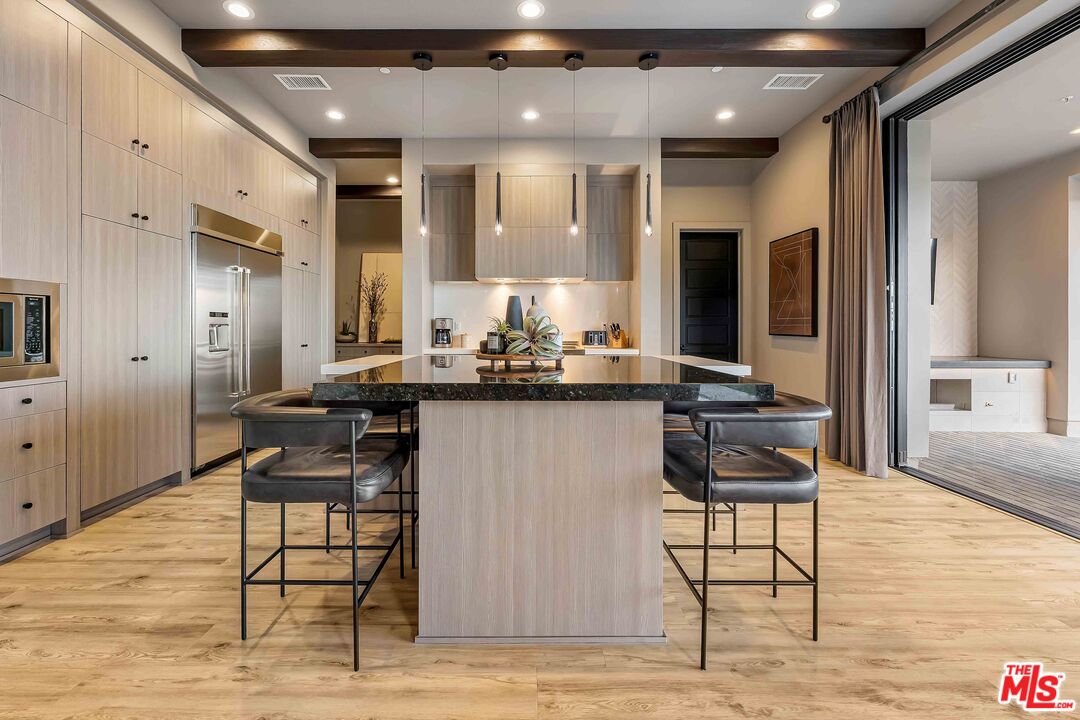 20524 Shelley Lane Porter Ranch, CA 91326 - Photo 21 of 73 a kitchen with stainless steel appliances kitchen island granite countertop a table chairs sink and cabinets