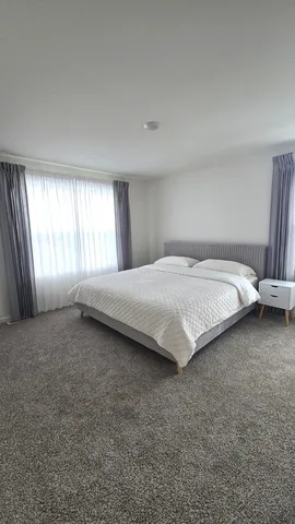a large bed sitting in a room next to a window