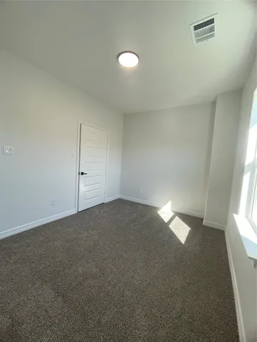 an empty room with a ceiling fan and windows