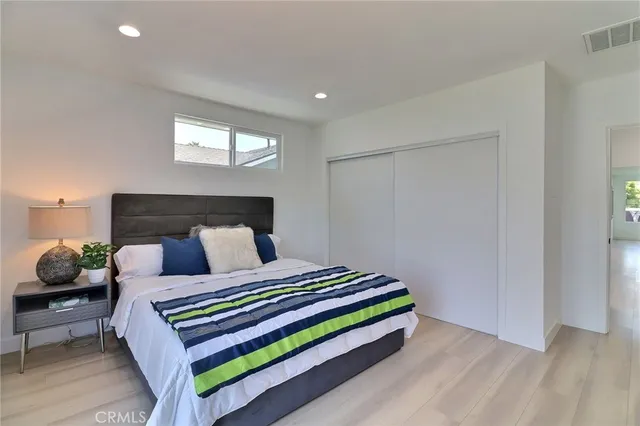 a bedroom with a bed and a potted plant