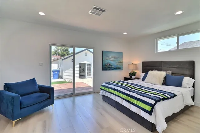 a bedroom with a bed couch and a large window