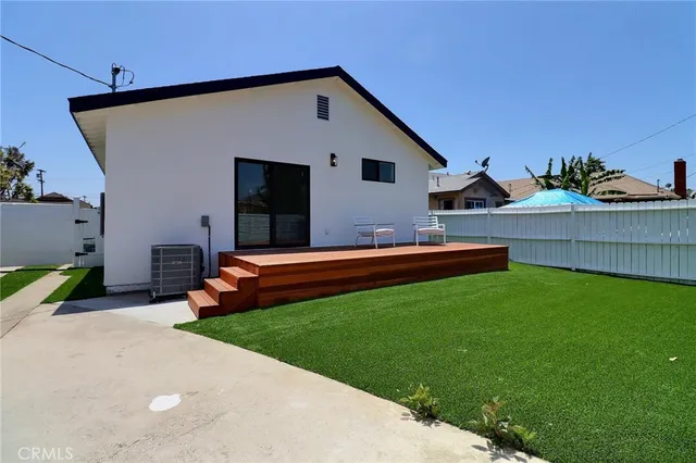 a backyard of a house with table and chairs