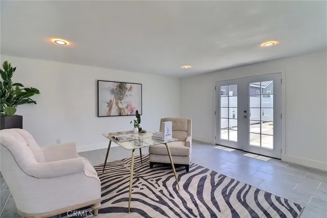 a living room with furniture two windows and wooden floor