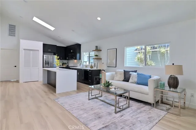 a living room with furniture and view of kitchen