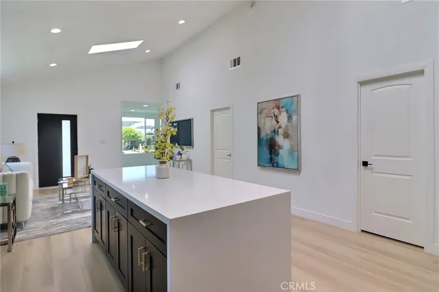 a view of kitchen island a sink wooden floor and living room