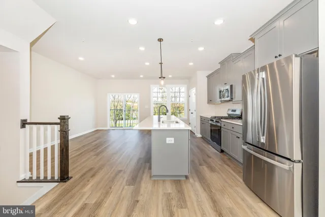 a large kitchen with granite countertop a large window appliances and cabinets