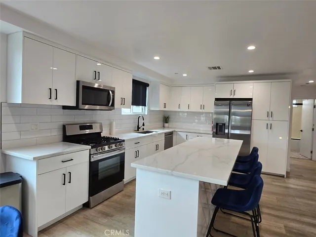 a kitchen with white cabinets and stainless steel appliances