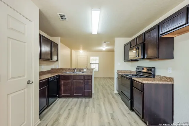a large kitchen with stainless steel appliances granite countertop a stove a sink dishwasher and a refrigerator