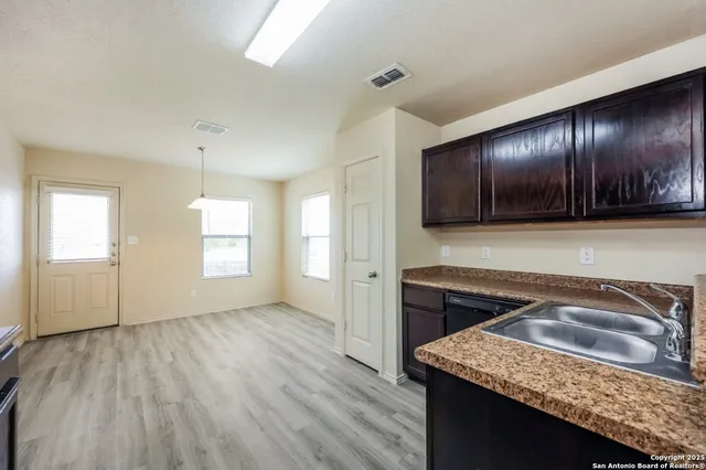 a kitchen that has a sink cabinets counter space and a stove