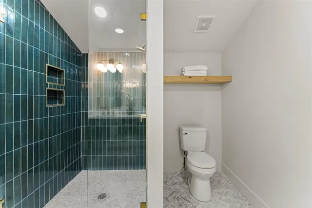 a bathroom with a toilet and a shower