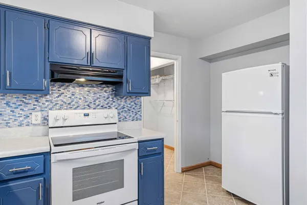 a kitchen with wooden cabinets and white appliances