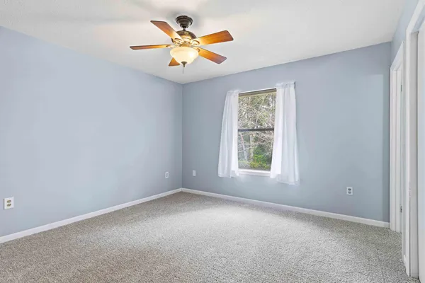an empty room with a window and a fan