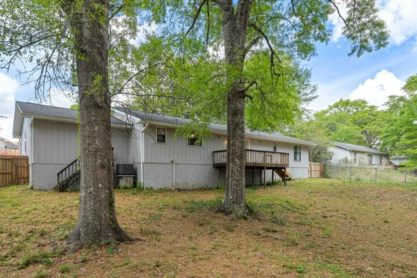 a view of a house with a large tree and a yard