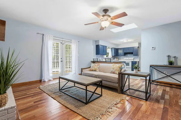 a living room with furniture kitchen view and a large window