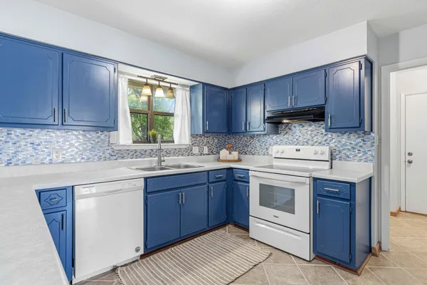 a kitchen with a sink stove and cabinets
