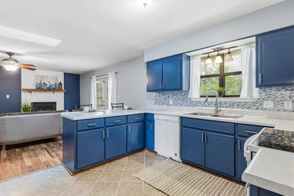 a kitchen with stainless steel appliances granite countertop a sink dishwasher stove and wooden cabinets