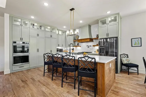 a kitchen with kitchen island a stove a table and chairs in it