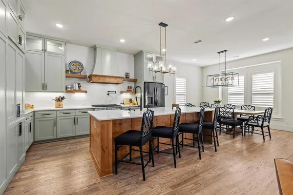 a kitchen with lots of wooden furniture appliances and furniture