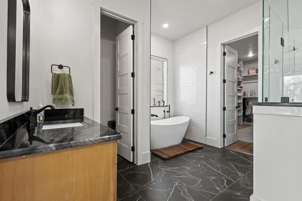 a large bathroom with a granite countertop tub sink and mirror