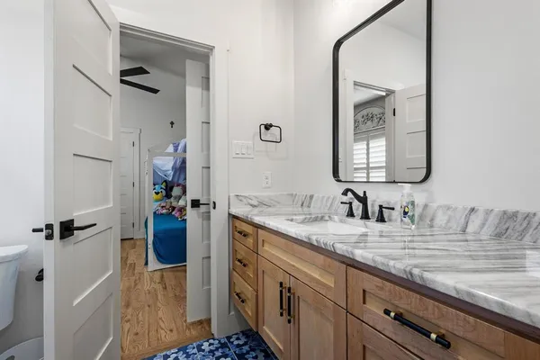 a bathroom with a granite countertop sink mirror and a shower