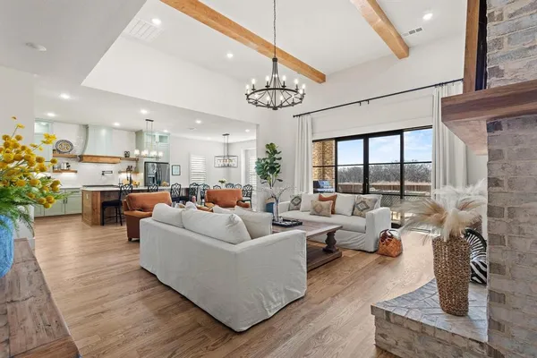 a living room with furniture dining table a large window with potted plants