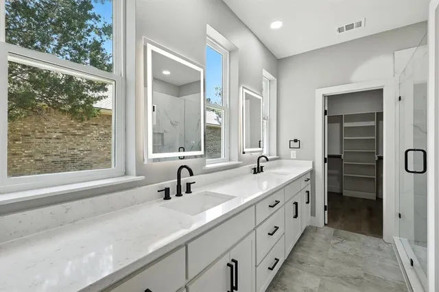 a spacious bathroom with double sink and a large mirror