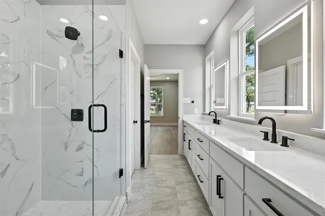 a bathroom with a double vanity sink a mirror and shower