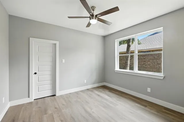 an empty room with a window and a ceiling fan