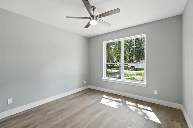 an empty room with a window and a fan