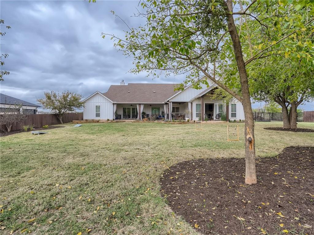 132 Huerta Road Florence, TX 76527 - Photo 34 of 40 An inviting rear exterior with a covered patio overlooks a generous lawn and established trees.