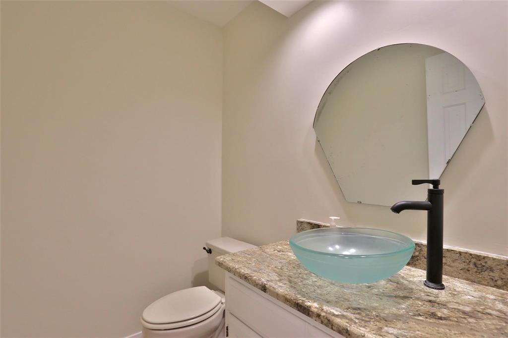 5717 Fm 2647 Winters, TX 79567 - Photo 22 of 37 a bathroom with a granite countertop toilet and a sink