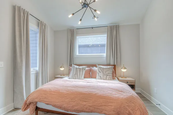 a bedroom with a bed and a chandelier