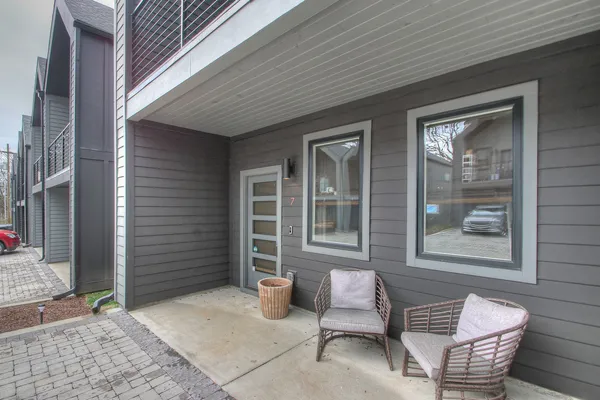 a balcony with table and chairs and a barbeque