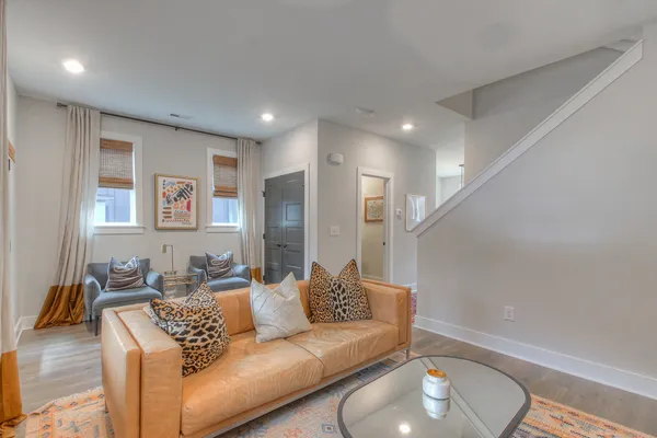 a living room with furniture and a wooden floor