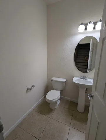 a bathroom with a toilet a sink and a mirror