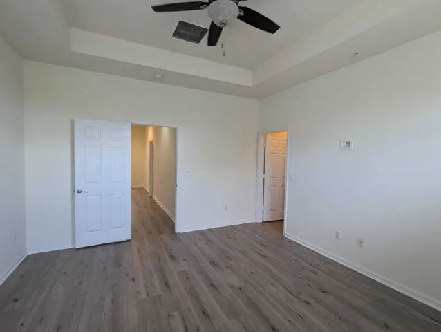 a view of an empty room with wooden floor