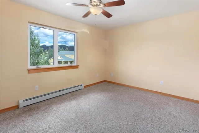 an empty room with a ceiling fan and a window